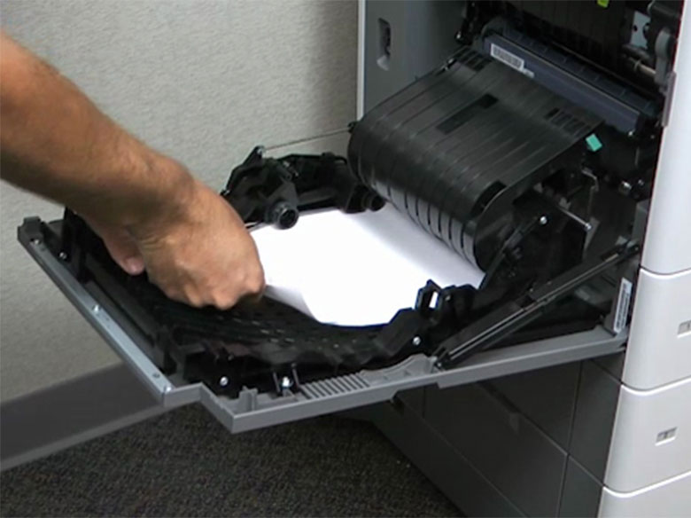 Deslice el pestillo y, a continuación, abra la cubierta de la unidad de impresión a doble cara para extraer el papel atascado.