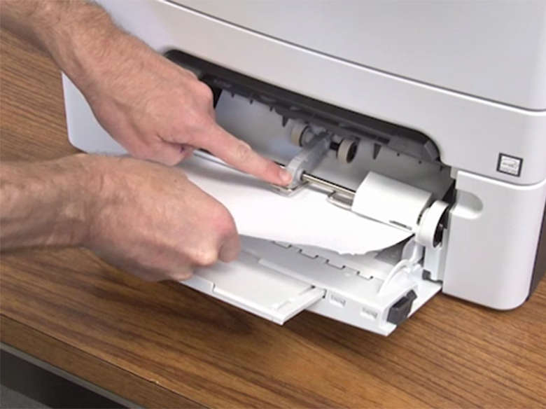 Retirez le papier coincé dans le chargeur multifonction.