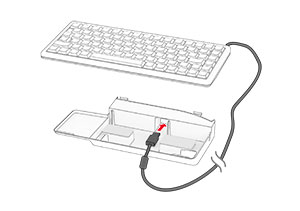 The cable is inserted into the hole found on the keyboard shelf.