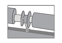 The metal spring is positioned in front of the roller.