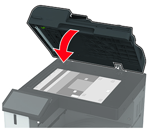 Il coperchio dello scanner viene chiuso, con gli adesivi rivolti verso di esso.